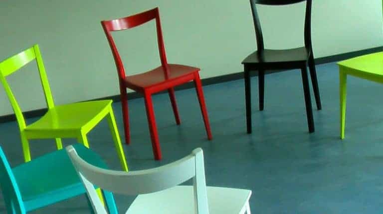 Разноцветные стулья расставленные кругом для корпоративного тренинга